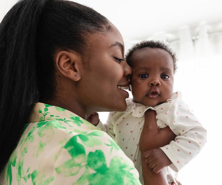 Mom holding baby, as baby has hiccups