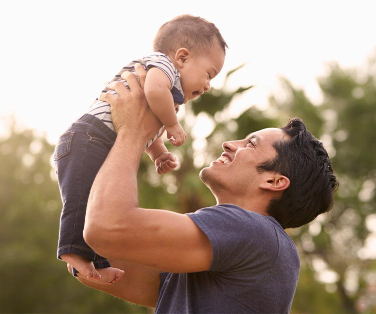 Dad lifting his son up in the air both smiling