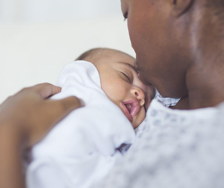 Mom kissing newborn on the head