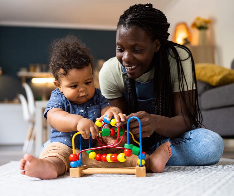 Mom and toddler playing with gear toys