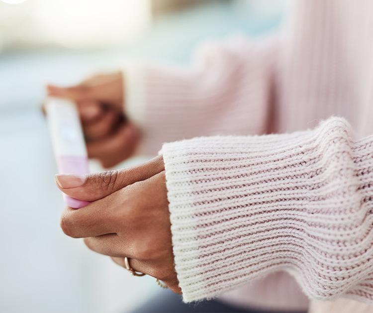 Close up of a woman holding a pregnancy test