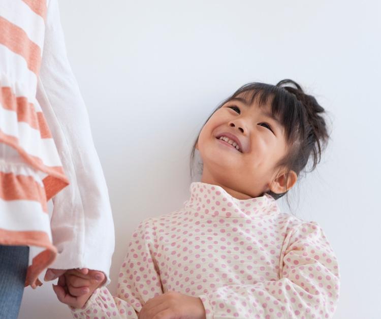 Toddler girl smiling up at mom