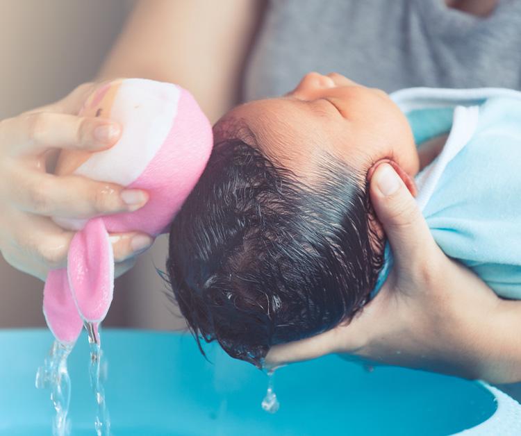 Mom bathing newborn baby