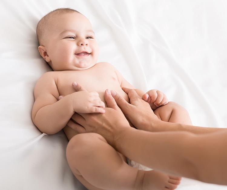 Newborn smiling as parent put hands on their belly
