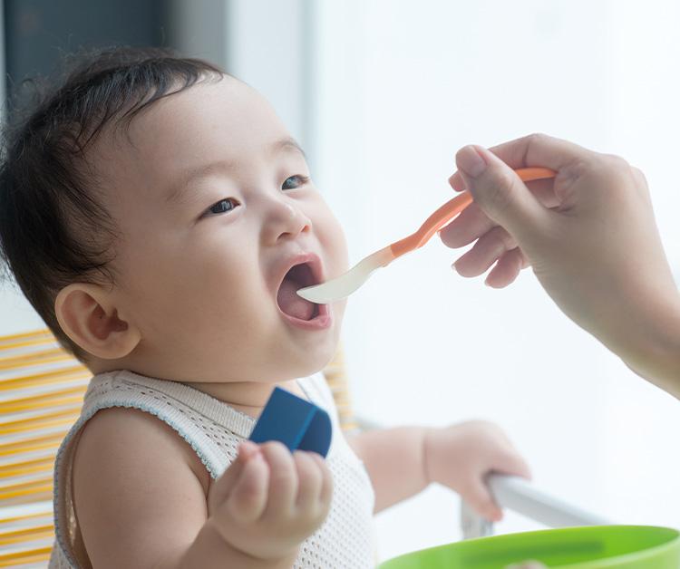 Mom spoon-feeding her baby