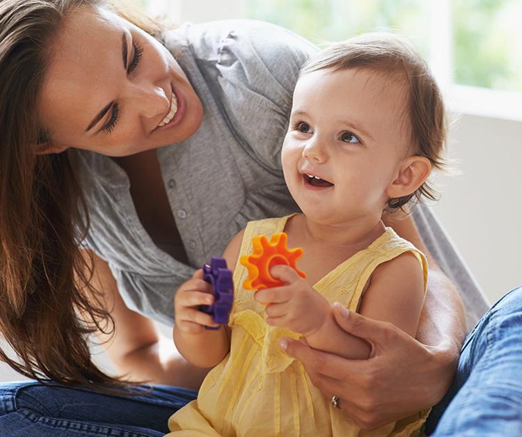 Little girl and mom playing with colorful toys