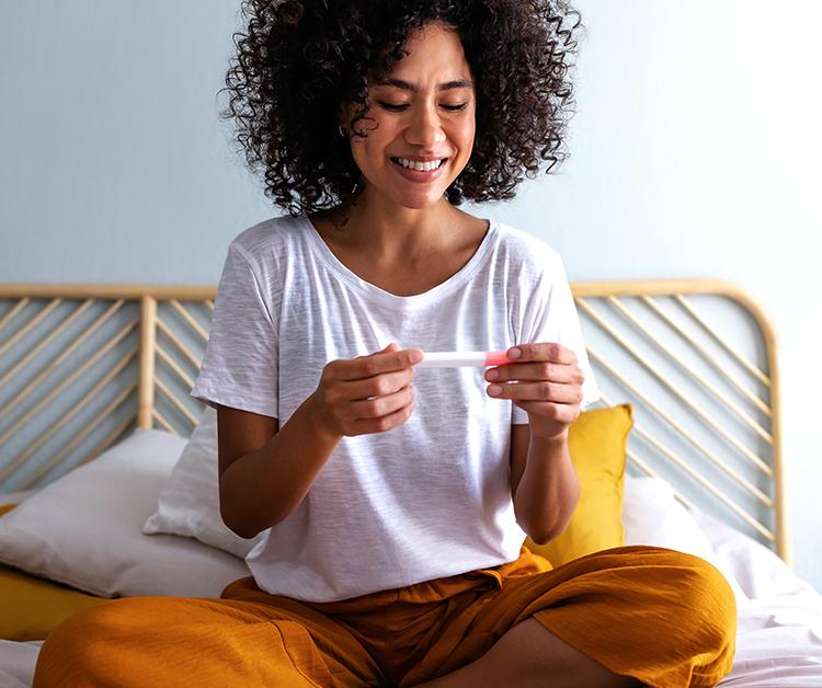 Smiling woman looking at pregnancy test