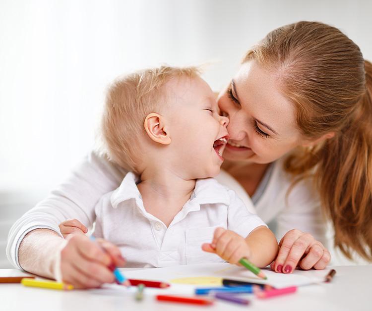 Mom and toddler son coloring with coloring pencils