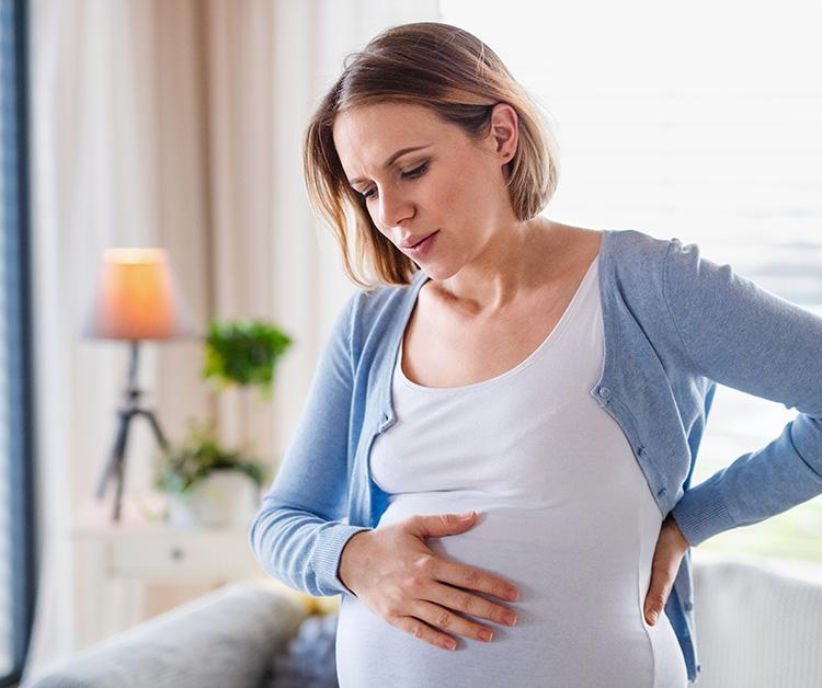 Mujer embarazada sosteniendo su estómago mientras tiene una contracción