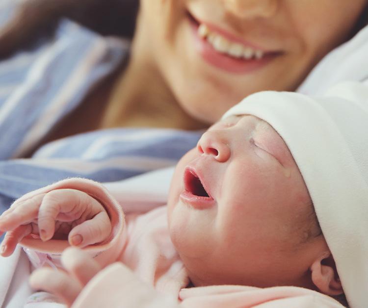 Close up of newborn baby laying next to mom