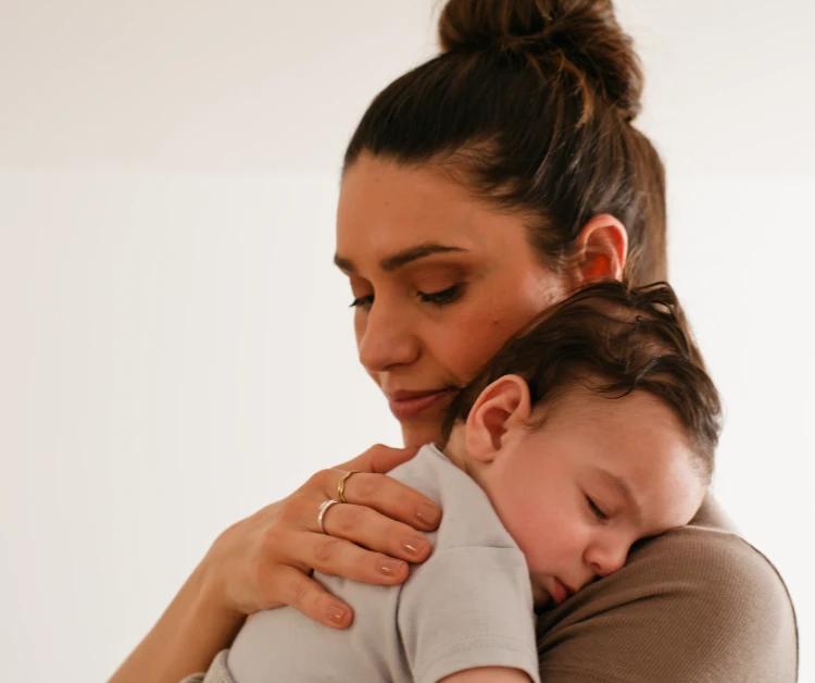 Mom holding sleeping baby